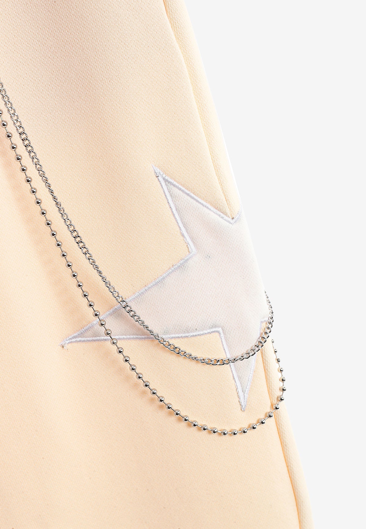 Pantalón jogger Wings con parches de estrellas y cadena lateral | MWM [PS_COLORS:BEIGE]